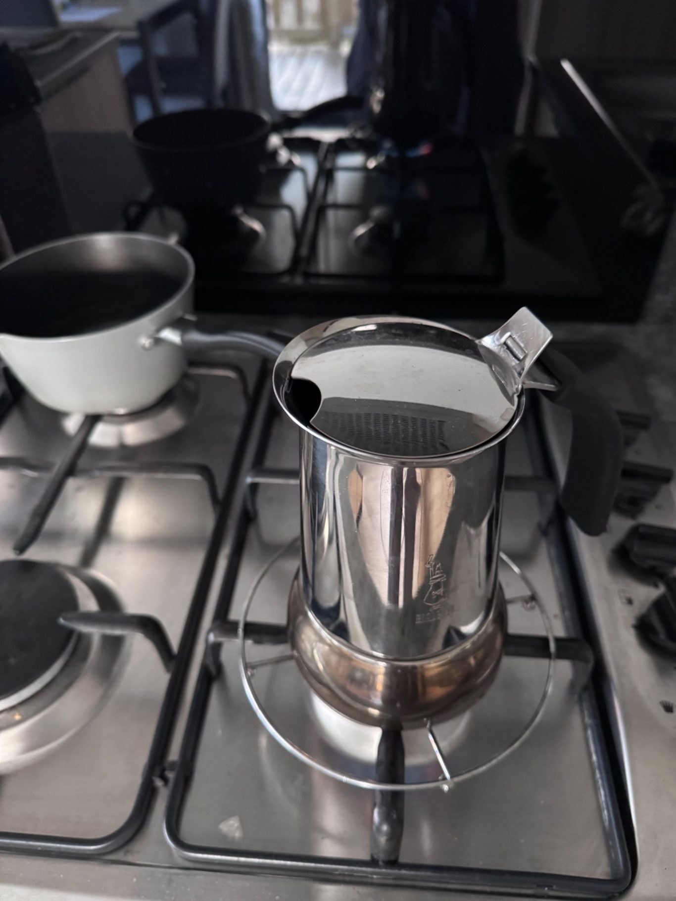 Espressokocher Ein Edelstahlkochtopf auf einem Herd, daneben ein kleinerer Topf.