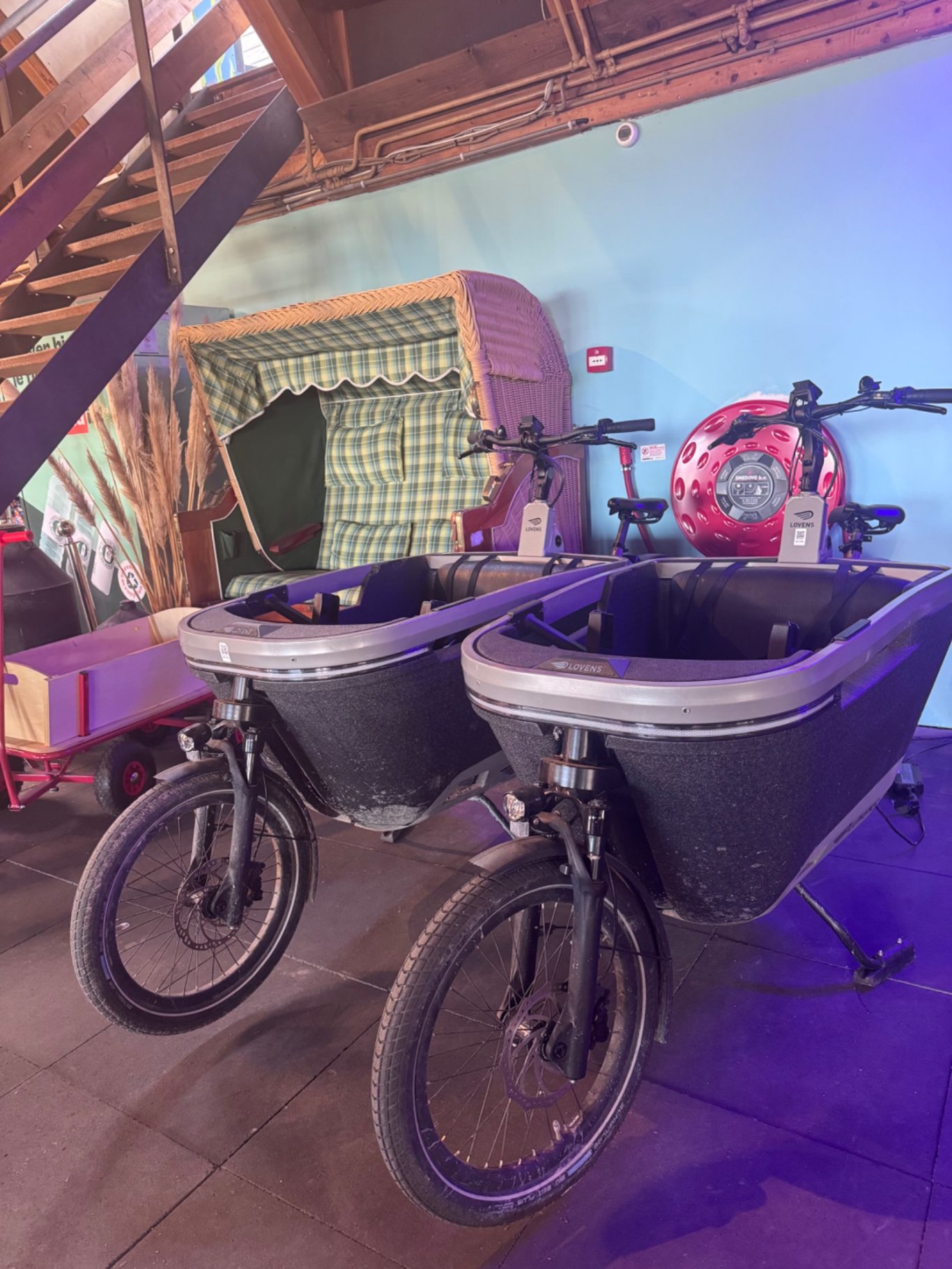 Fahrradverleih Zwei Lastenfahrräder mit schwarz-silberner Farbe in einem dekorierten Raum.