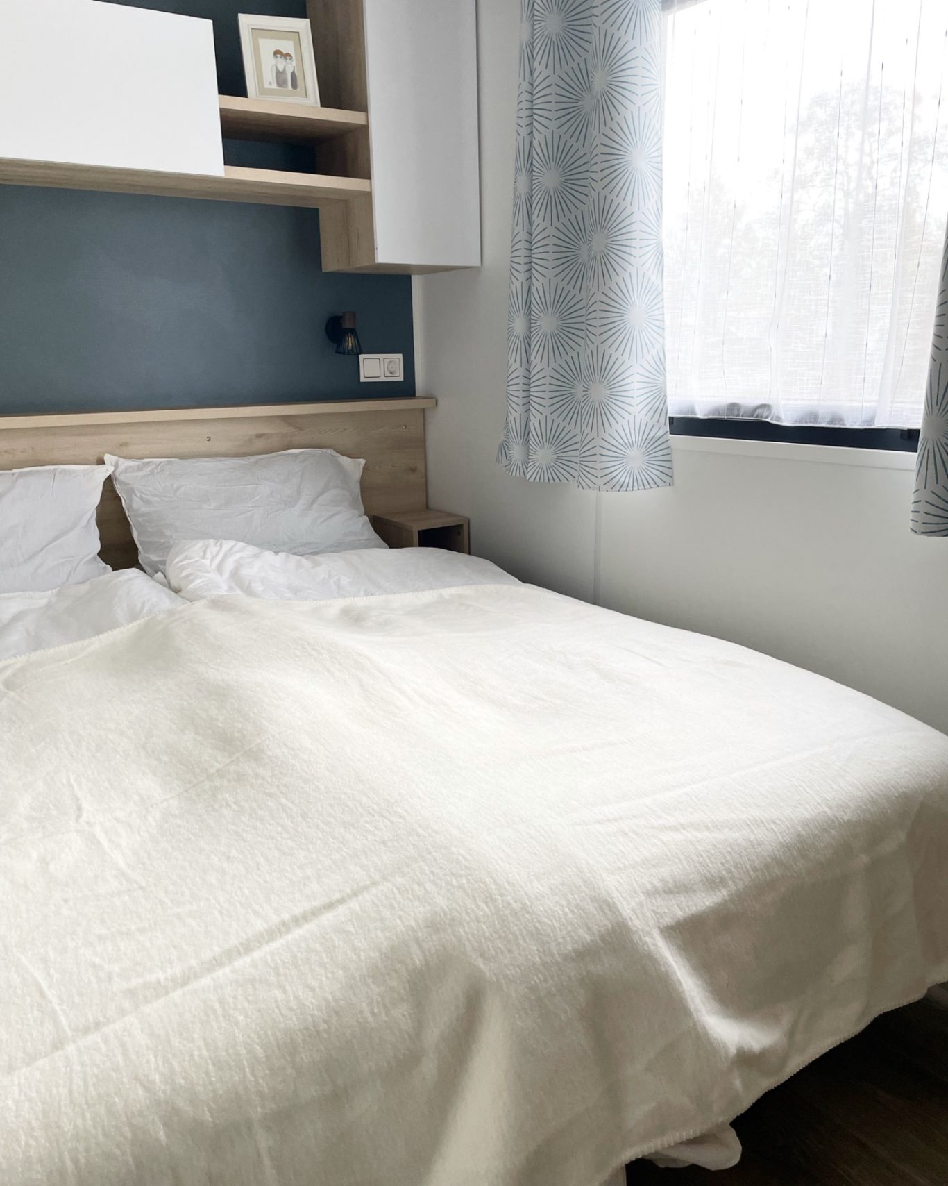 Schlafzimmer 1 Ein schlichtes Schlafzimmer mit einem Bett und hellen Vorhängen.