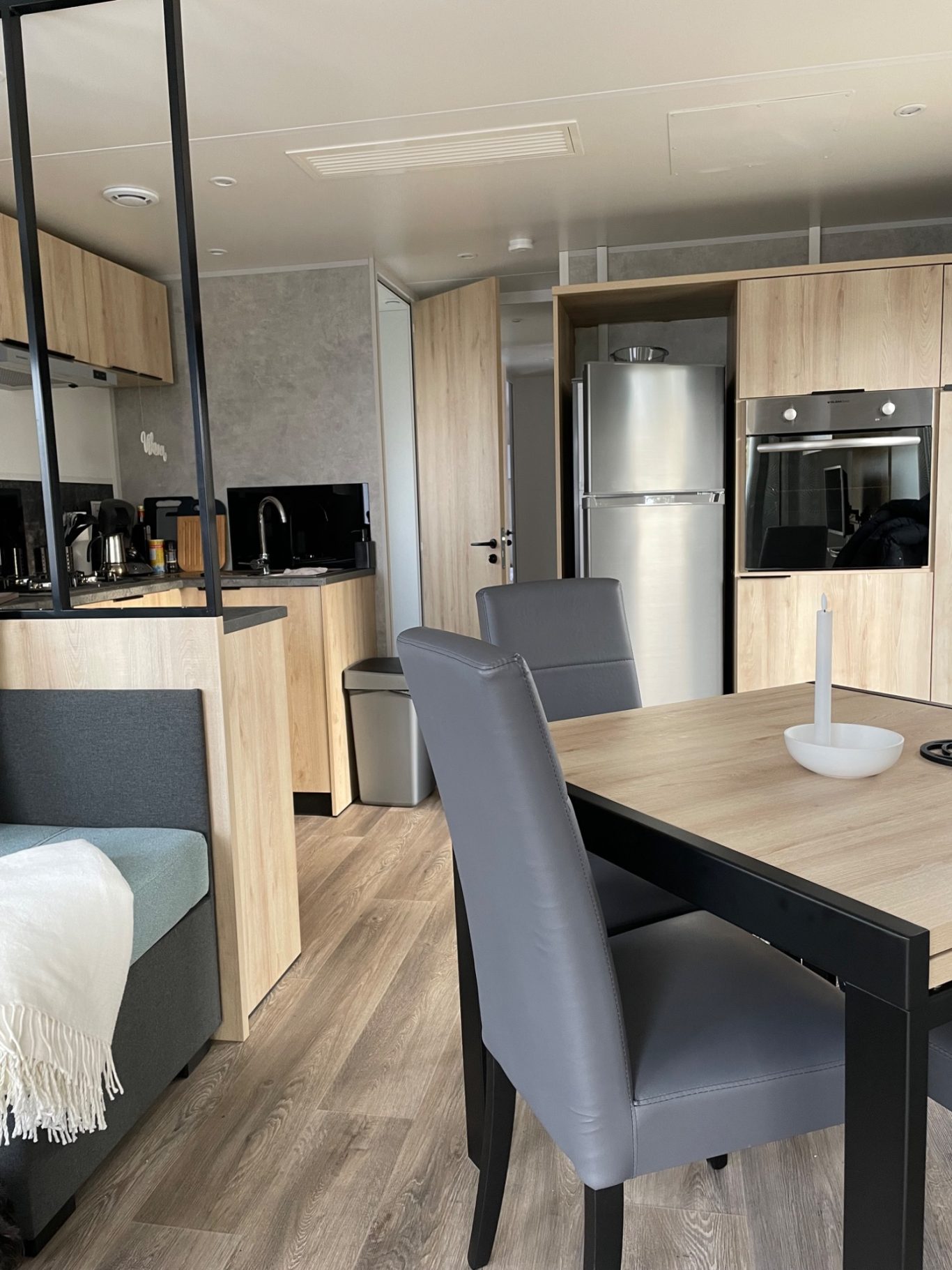 Wohnraum Moderne Küche mit Holzschränken, Tisch und Stühlen, ausgestattet mit Geräten.