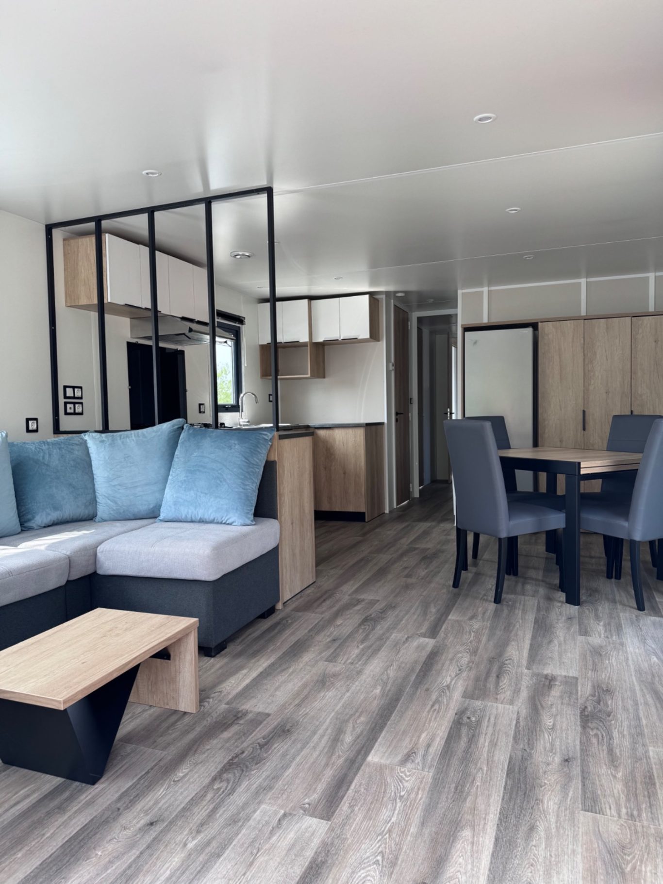 großer Wohnbereich Moderne, helle Wohnküche mit Sofa, Esstisch und Holzfußboden.