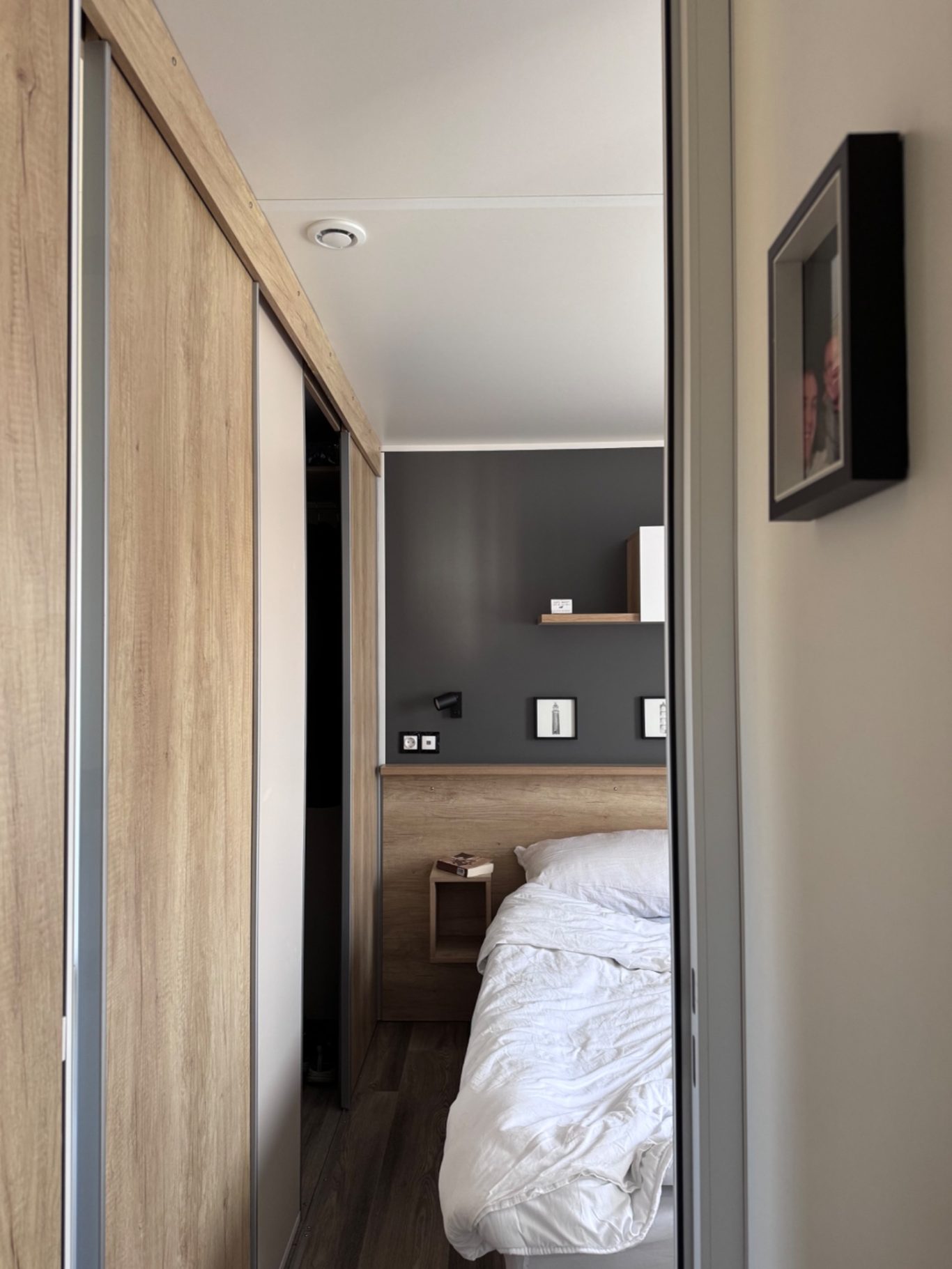 Hauptschlafzimmer Blick in einen modernen, hellen Raum mit Bett und Holzwänden.