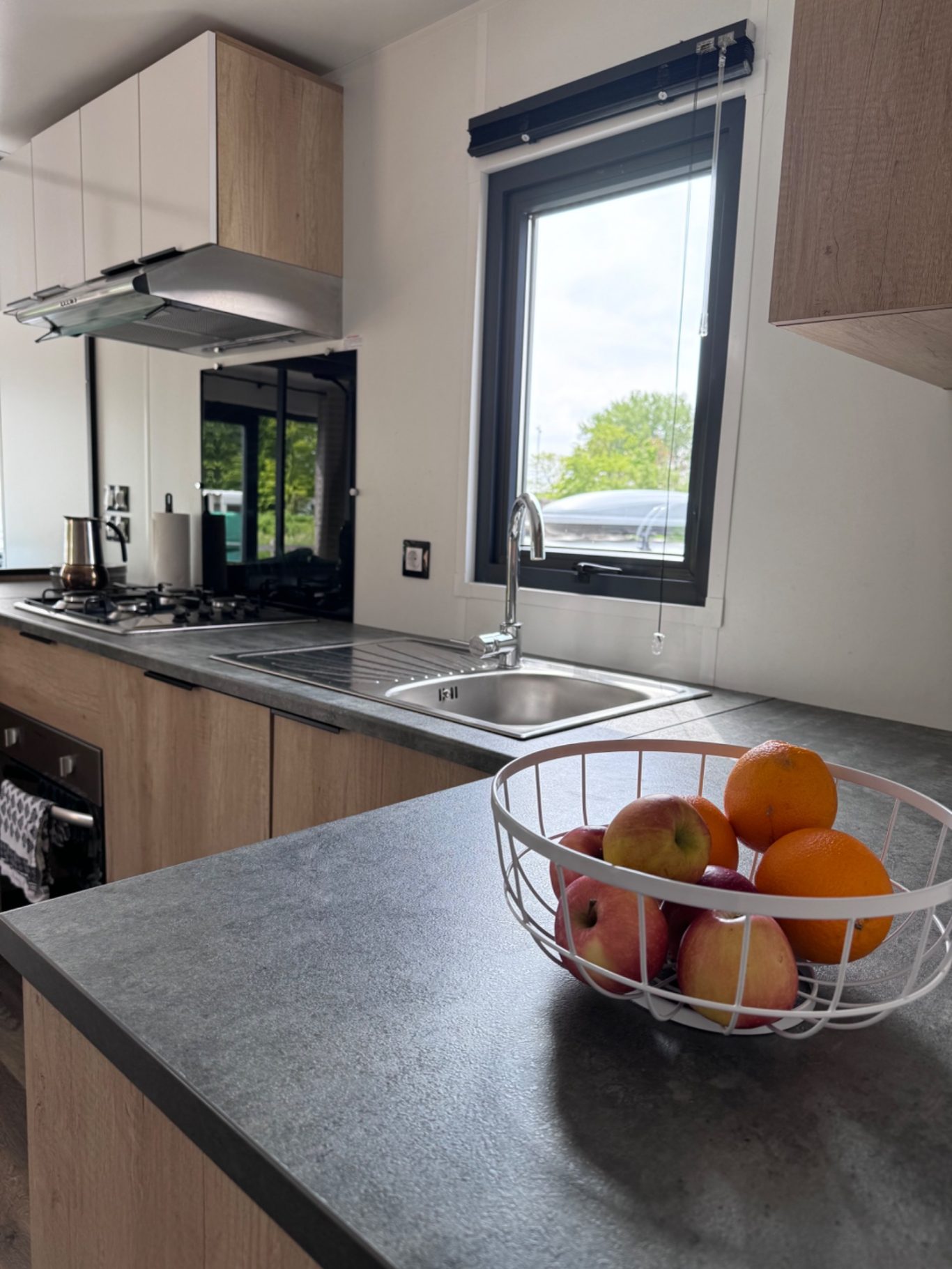 Küche Küche mit modernem Design, Spüle und Obstschale auf der Arbeitsplatte.